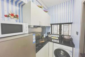 香港apt 4BR10pax, 2bar ,1mins mtr的厨房配有洗衣机和微波炉。