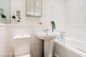 纽伯里Central 3 bed apartment at Regents Court, Newbury的白色的浴室设有水槽和卫生间。