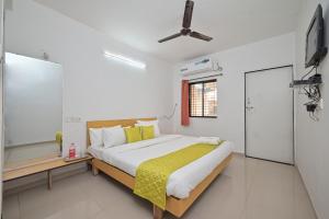 萨普塔拉Jalsa Villas的一间卧室配有一张床和一台平面电视