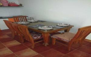 班加罗尔Mango Ville的一张木桌,上面有椅子和盘子
