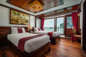 下龙湾Indochina Sails Ha Long Bay Powered by ASTON的一间带两张床的卧室和船上的阳台