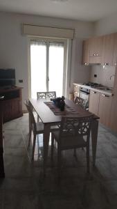 潘泰莱里亚Casetta Cavour的厨房配有木桌、椅子、桌子和桌子