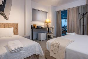 扎金索斯镇AMINA APARTMENTS的酒店客房配有两张床和一张书桌