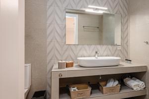 扎金索斯镇AMINA APARTMENTS的一间带水槽和镜子的浴室