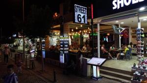 萨利杰尔梅Street61 Apart Hotel的一群人晚上坐在餐厅外面