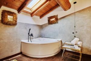 科莫米兰多拉科尔尼拉农家乐的带浴缸的浴室和木制天花板