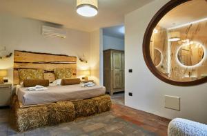 科莫米兰多拉科尔尼拉农家乐的一间卧室设有一张大床和一个大镜子