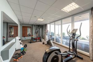 卡鲁扎魅力酒店的一个带跑步机和椭圆机的健身房,位于带窗户的房间内
