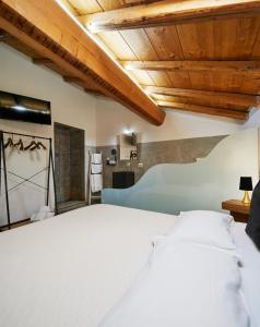 科莫米兰多拉科尔尼拉农家乐的配有木制天花板的客房内一张白色大床