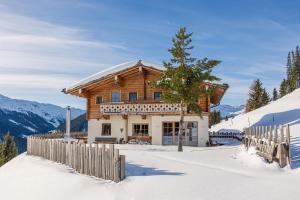 萨尔巴赫Wallegg Lodge - Alpine Premium Chalet - Ski In-Ski Out的雪中带围栏的木屋