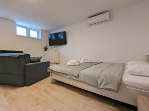 萨格勒布Yellow Pup in Maksimir的一间卧室配有一张床、一张沙发和一台电视