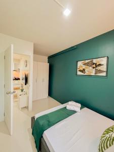 公主港2 Bedroom and 1 Bedroom Apartments with Private Pool and Gym的一间卧室设有绿色的墙壁和一张床