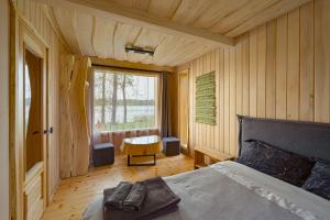 巴尔维Pirtsmāja diviem Līčezeri的一间卧室配有一张床、一张桌子和一个窗户。