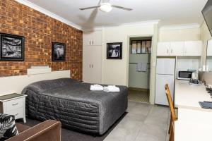 BenarabyBenaraby Hilltop MotorInn的一间卧室设有一张床和砖墙