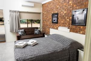 BenarabyBenaraby Hilltop MotorInn的一间卧室设有一张床和砖墙