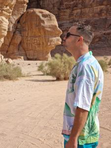 瓦迪拉姆Adel rum camp bubbles的站在沙漠中亲吻岩层的人