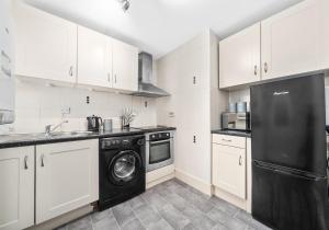 科特布里奇Garturk Apartment by Klass Living Coatbridge的厨房配有白色橱柜和黑色洗碗机