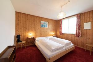 维尔德豪斯Sonnhalde的卧室设有一张白色大床和一扇窗户。