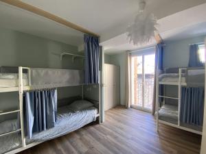 昂蒂布Bohobos Hostel的客房设有两张双层床和一扇窗户。