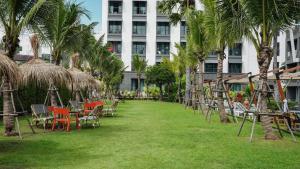 卡伦海滩Sugar Marina Hotel - ART - Karon Beach - SHA Plus的楼前带桌椅的草坪