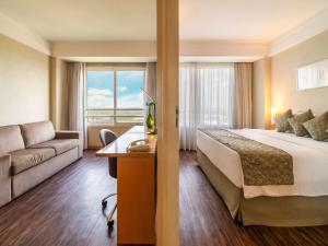 瓜鲁柳斯瓜鲁柳斯机场美居酒店的酒店客房,配有床和沙发