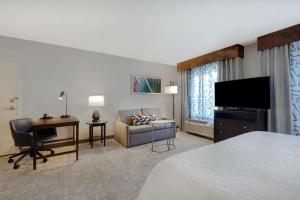 圣路易斯-奥比斯保汉普顿圣路易斯奥比斯波套房酒店的酒店客房配有一张床、一张书桌和一台电视。