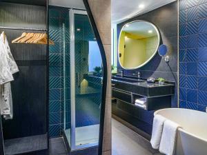 圣地亚哥Pullman Santiago El Bosque的带浴缸和镜子的浴室