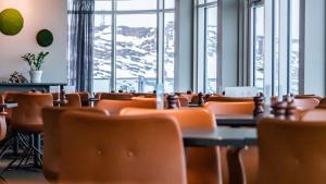 伊卢利萨特Best Western Plus Hotel Ilulissat的用餐室设有桌椅和窗户。