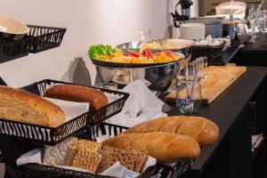 伊卢利萨特Best Western Plus Hotel Ilulissat的桌子上放着一篮面包和其他食物