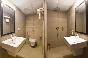 加尔各答FabHotel Sayeeda International的一间带两个盥洗盆、淋浴和卫生间的浴室