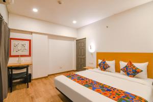 加尔各答FabHotel Sayeeda International的配有一张床和一张书桌的酒店客房