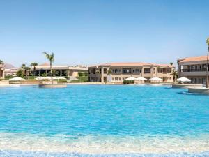 沙姆沙伊赫Rixos Golf Villas And Suites Sharm El Sheikh的建筑前方的一大片蓝色海水