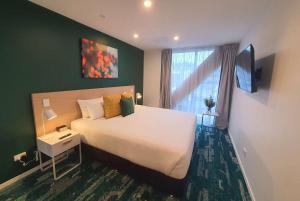 奥克兰La Quinta by Wyndham Ellerslie Auckland的卧室设有一张白色大床和一扇窗户。