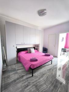 陶尔米纳Casa Viola - Al Centro的一间卧室配有一张粉红色的床和紫色床单