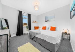 阿丁斯顿McCulloch Apartment by Klass Living Uddingston的一间卧室配有一张带橙色枕头的大床