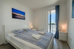 普利拉卡Villa Miri III的白色卧室配有一张带蓝色和白色床单的大床