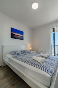 普利拉卡Villa Miri III的白色卧室配有带条纹枕头的大床