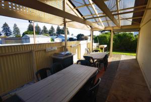 长滩港Beachport Motor Inn的户外庭院配有桌椅和遮阳篷。