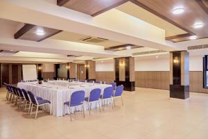 波尔沃林Hotel Orion Centrally near North Goa & Panjim的一个带白色桌子和蓝色椅子的大型宴会厅