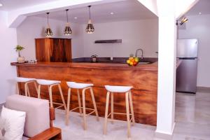 塔那那利佛Ampifitia Guest House的厨房设有木吧台和白色凳子
