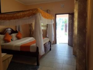 纳库鲁Allamanda Gardens Resort的一间卧室配有一张带天蓬的床