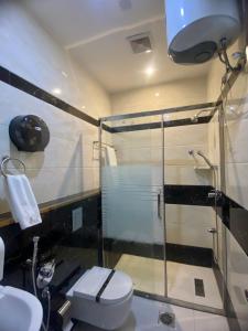泰布克Aral Hotel Apartments的一间带玻璃淋浴和卫生间的浴室