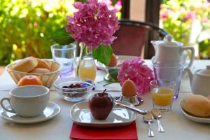 圣费利切德尔贝纳科圣费利丝酒店的一张带早餐食品的桌子和一瓶粉红色的花