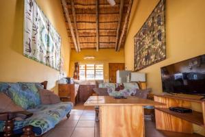 卡萨内African Sunsets (Bophirimo Self-Catering Guest House)的带沙发和平面电视的客厅