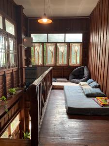 Kampong HuaibūYor Song Hostel Pai的客房设有床、沙发和窗户。