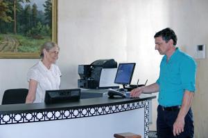 喀山撒拉逊波尔沙雅卡拉斯拉雅旅馆的男人和女人站在桌子上,用电脑