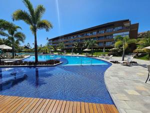 塔曼达雷Eco Resort Praia dos Carneiros - Flats & Bangalô - LocarHouse的一座游泳池,其后方是一座度假村建筑