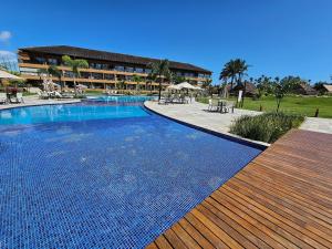 塔曼达雷Eco Resort Praia dos Carneiros - Flats & Bangalô - LocarHouse的一个带桌椅的度假村游泳池