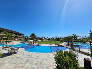 塔曼达雷Eco Resort Praia dos Carneiros - Flats & Bangalô - LocarHouse的度假村的游泳池,配有椅子和遮阳伞
