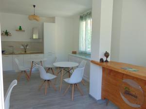 夸尔图-圣埃莱娜Stasonis的厨房配有白色的桌椅和柜台。